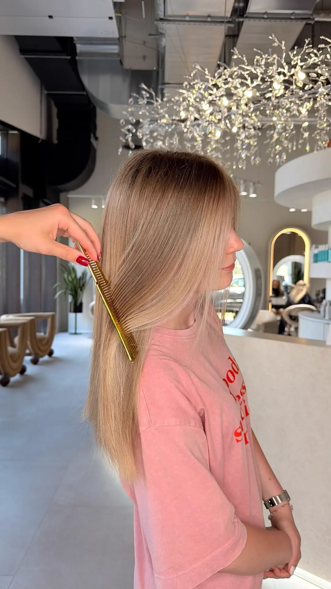 Lange blonde Haare werden mit einem goldenen Kamm durchgek&auml;mmt