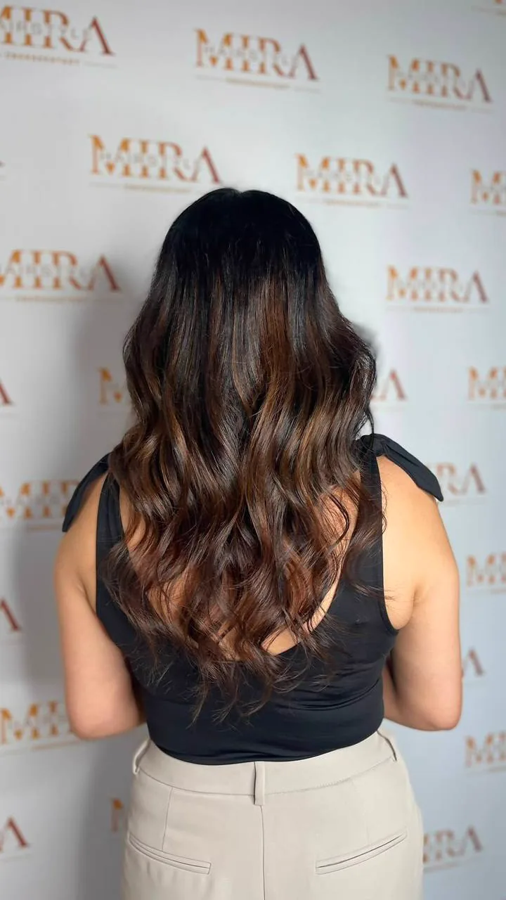 Dunkle Haare mit karamellfarbenem Balayage in weichen Wellen