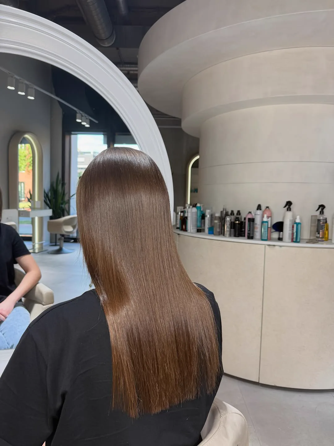 Lange braune Haare, glatt und gl&auml;nzend, am Empfang des Salons